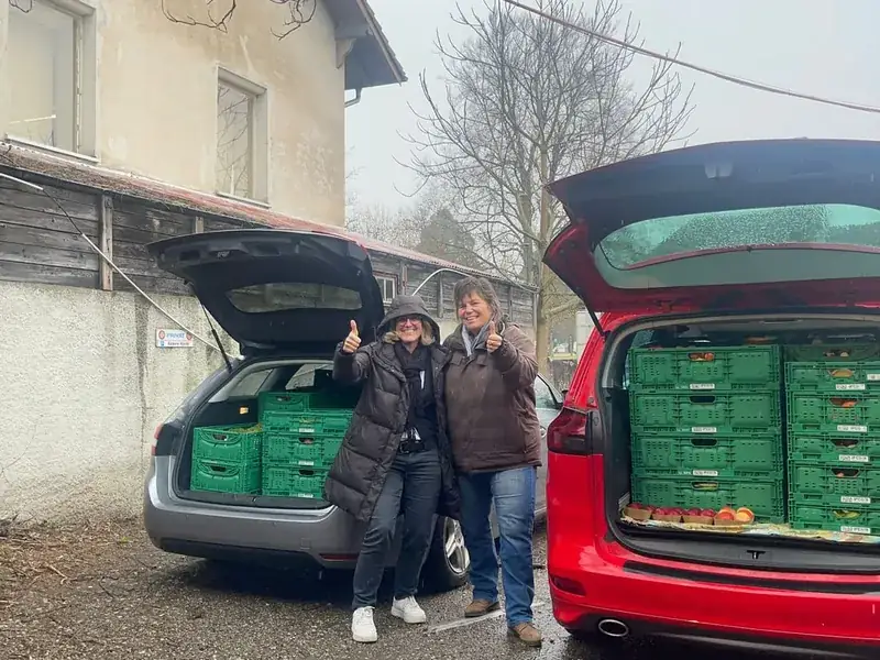 Zwei Freiwillige nach einer Sammeltour, beide Autos vollbeladen mit Kisten voller geretteter Lebensmittel